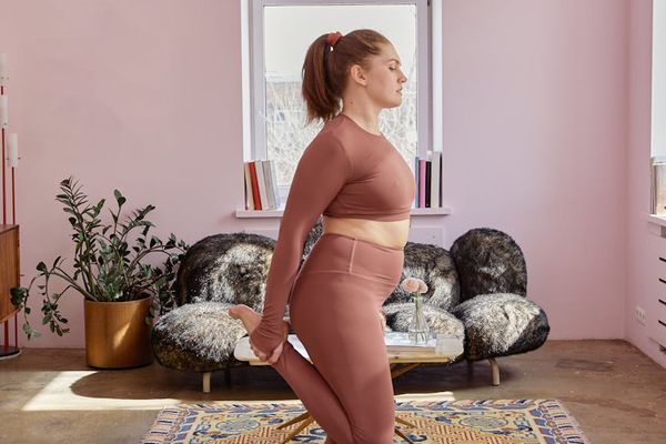 Person in a calm, focused pose in a minimalist, well-lit room.
